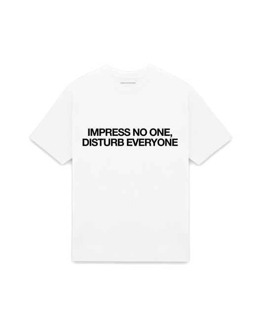 White oversized t-shirt with IMPRESS NO ONE, DISTURB EVERYONE printed in Helvetica across the chest, AS Colour Heavy Tee 5080.
